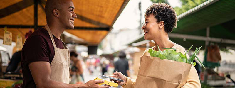 Mujer pagando con contactless en un mercado