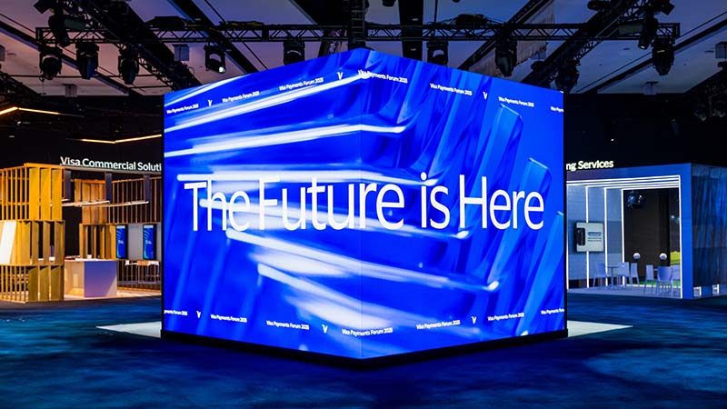 Cube-shaped screen at Visa Payments Forum 2025 reads The Future is Here.